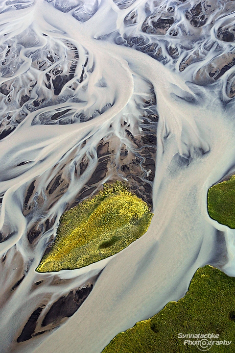Aerial image of a green island in an Icelandic river