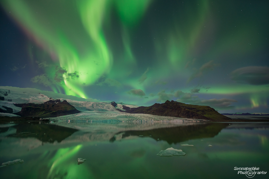 Green aurora explosion at Fjallsarlon Glacier lagoon