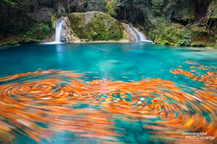 Urederra waterfall and foliage swirls in the turquoise pools
