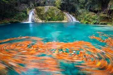 Urederra waterfall and foliage swirls in the turquoise pools