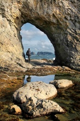 Hiker at Hole in the Wall at Rialto Beach - Olympic National Park