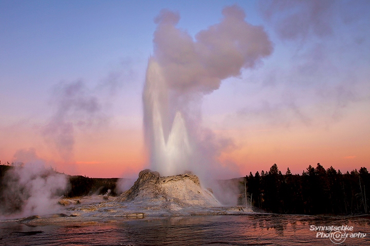 Castle Geyser eruption at sunset